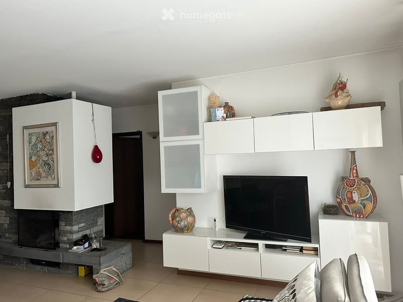 white walls, fireplace, flat screen TV, white cabinets, decorative items