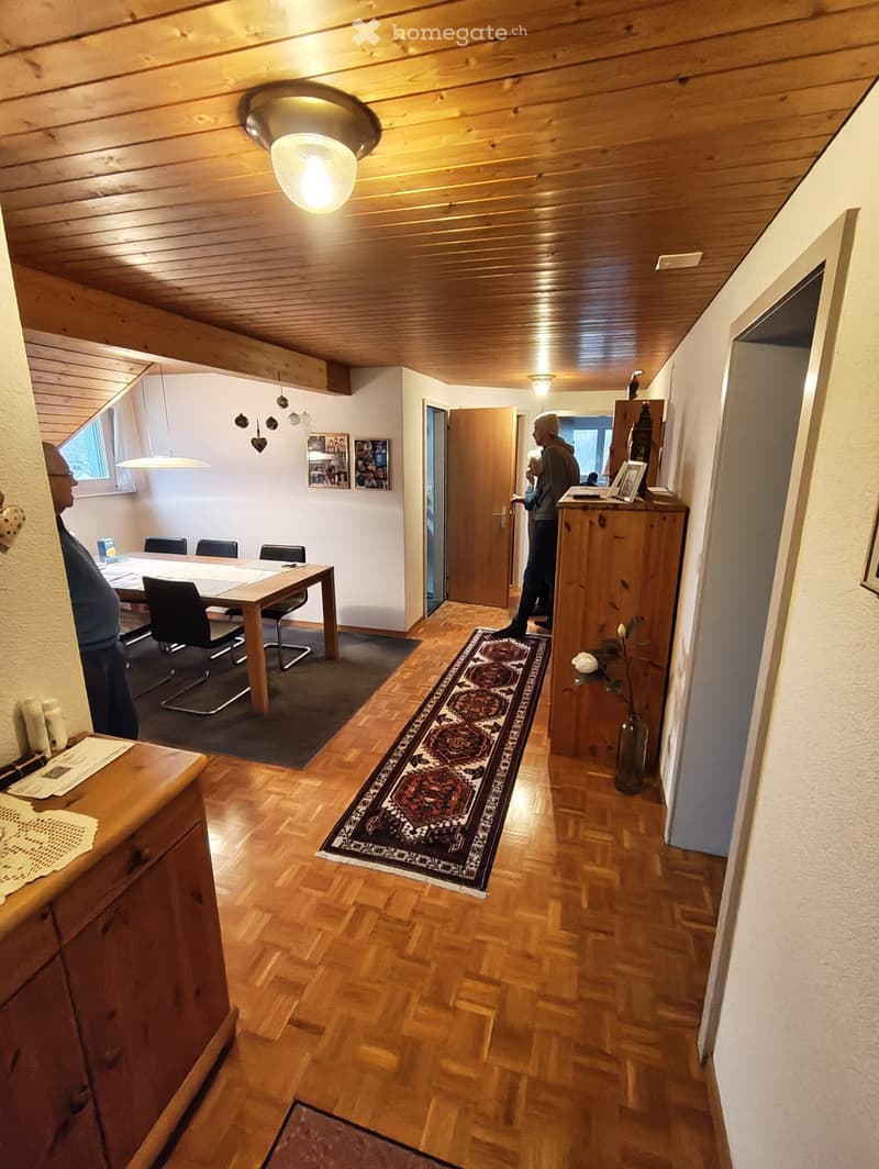 dining table, wooden chairs, wooden floor, chandelier, picture frames, wooden cabinet