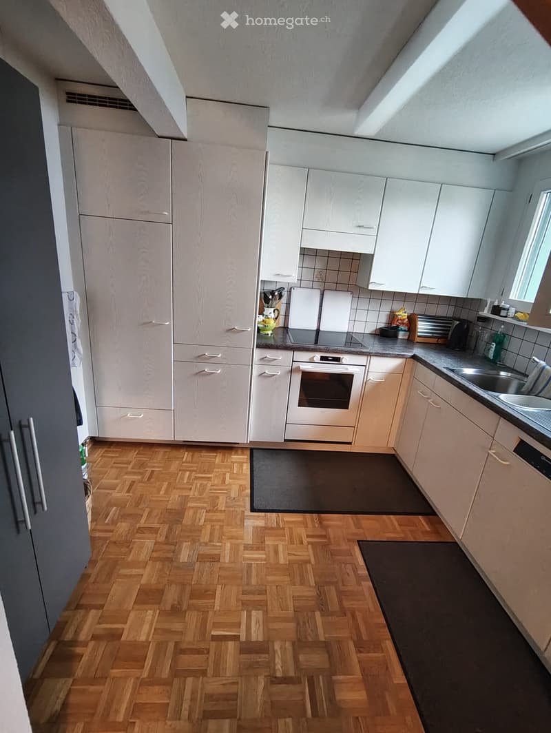 kitchen with parquet floor, white cabinets, gray countertops, white appliances, black rugs, sink