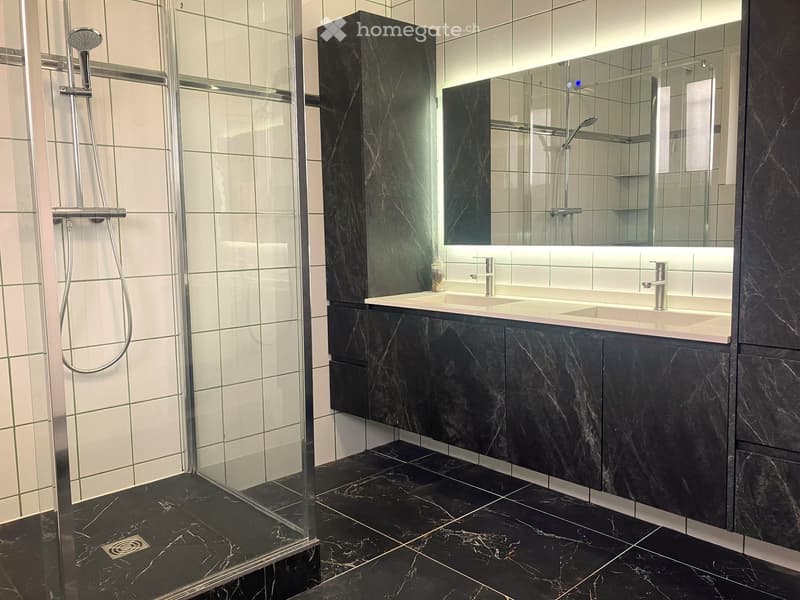 black marble flooring, white tiled wall, double vanity, mirror, shower