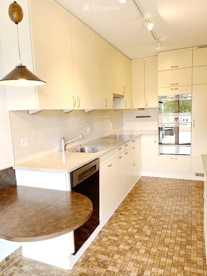 modern kitchen, tiled flooring, granite countertop, wooden table, stainless steel appliances, faucet