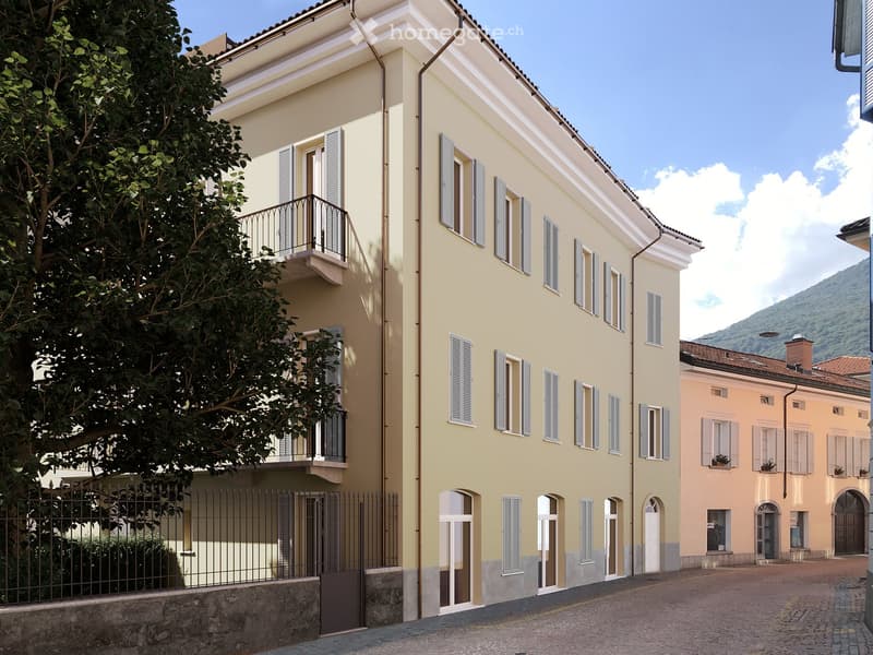 3 story building, yellow exterior, black railings on balcony, multiple windows