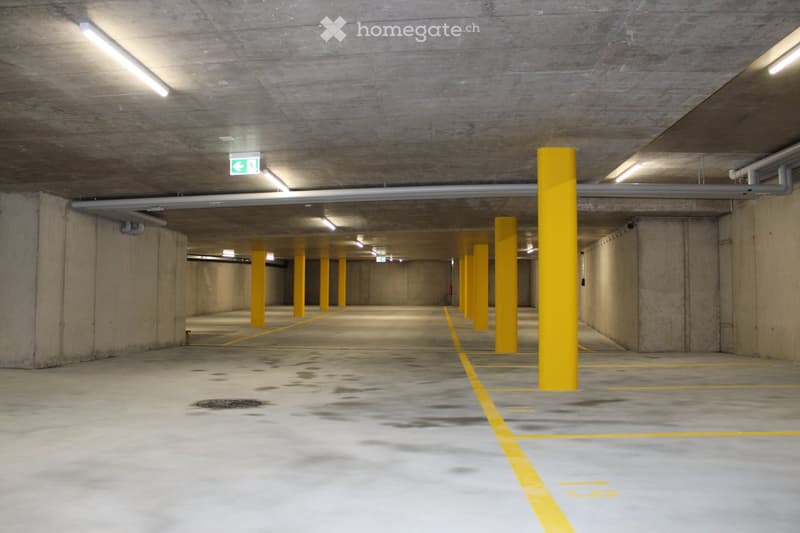 Empty underground parking area with yellow pillars and parking spots