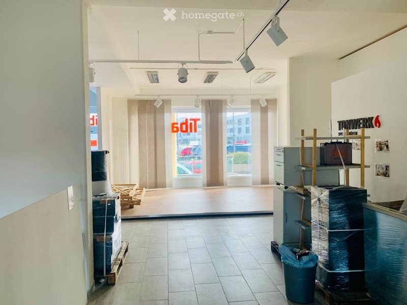 empty office, wooden floor, large window with curtains, light fixtures, storage boxes and barrels