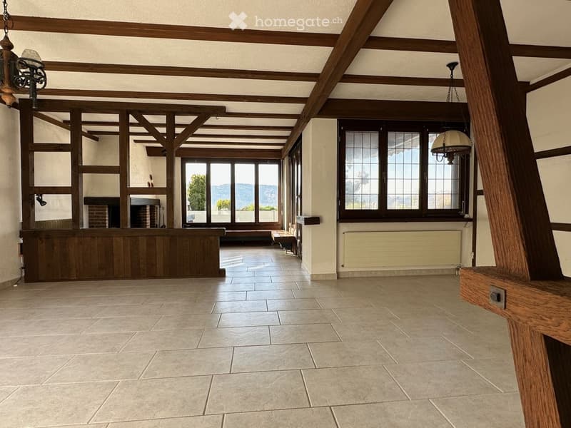 Wooden beams, tiled floor, large windows, fireplace, radiator, wooden beams