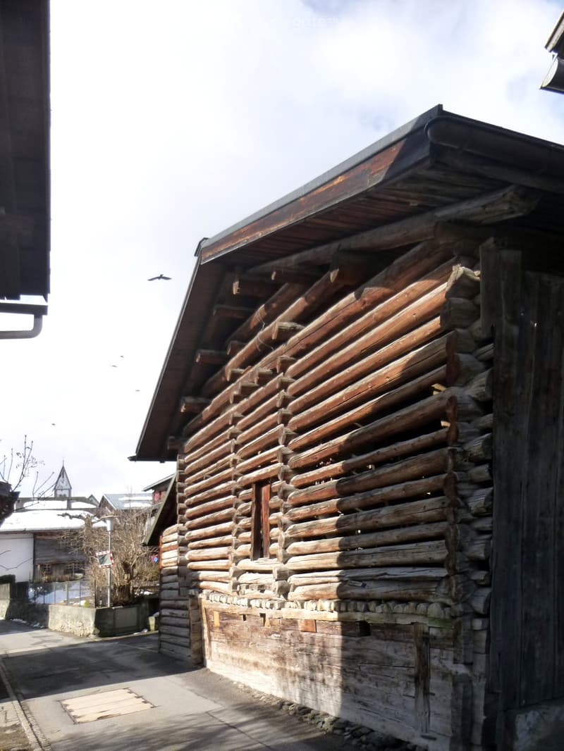 a wooden log house on a street corner