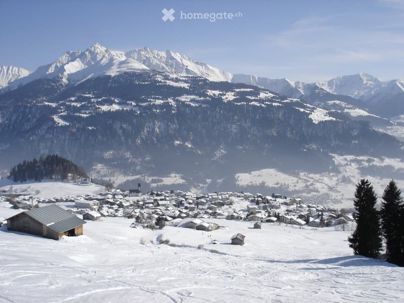 Snow-covered mountainous landscape with a village in the valley