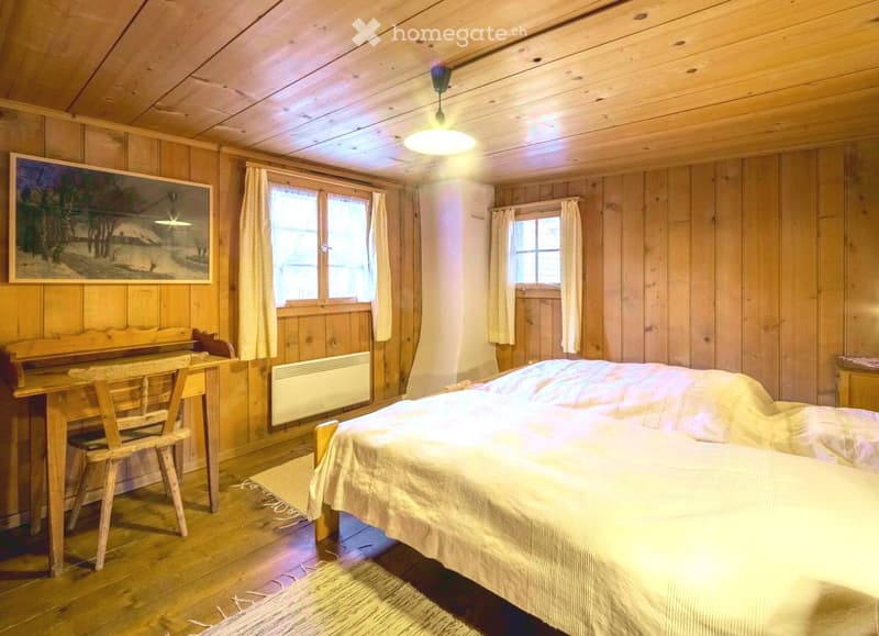 wooden walls, wooden ceiling, double bed, wooden desk, wooden chair, windows with curtains, heater, carpet, painting