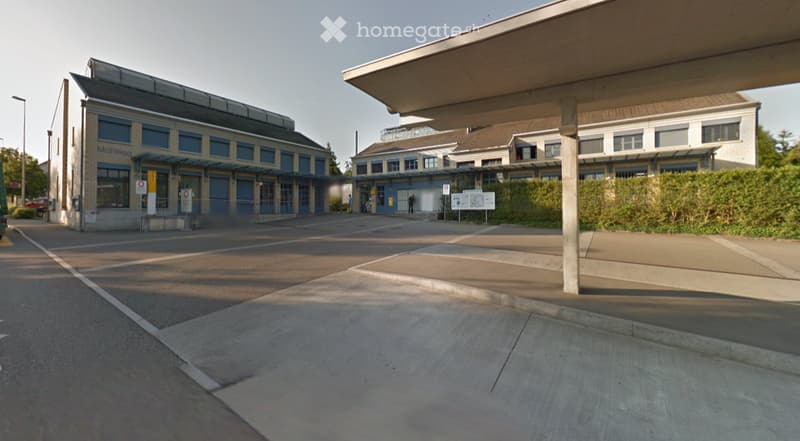 large parking lot, modern buildings, large windows, trees, streetlight