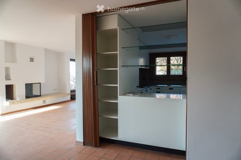 tiled floor, fireplace, wooden bench, glass shelves, white kitchen with wooden accents, white walls