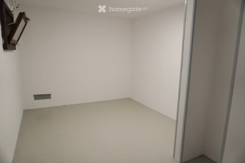 empty room, white walls, gray floor, small window, air vent