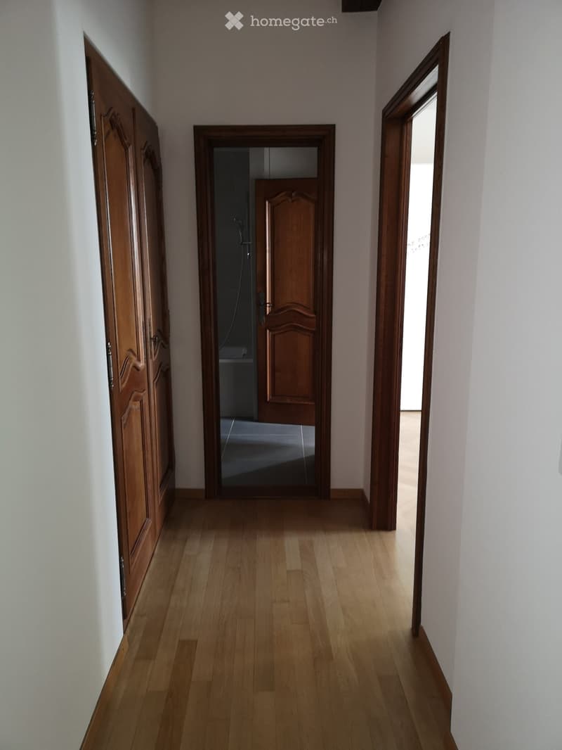 corridor with wooden floors, wooden doors, empty rooms