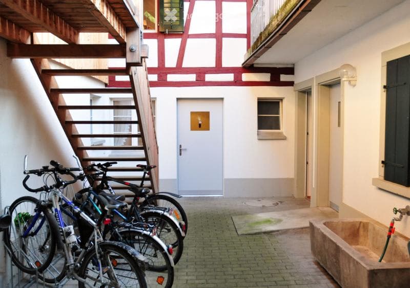 Parking area for bicycles, with brick floor and wooden staircase