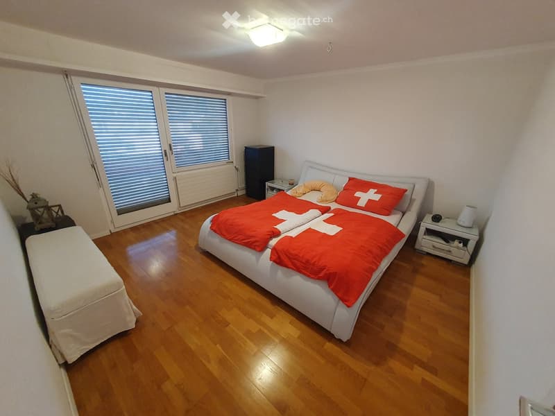 double bed, wooden floor, white walls, nightstands, sliding glass door, ceiling lamp