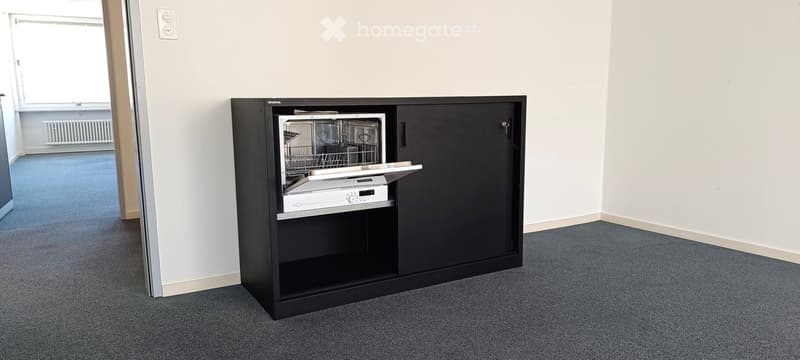 Empty room with a black cabinet with a dishwasher inside