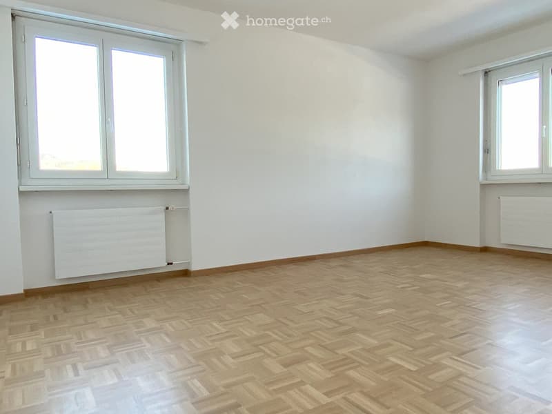 empty room, white walls, wooden floors, two windows, radiators