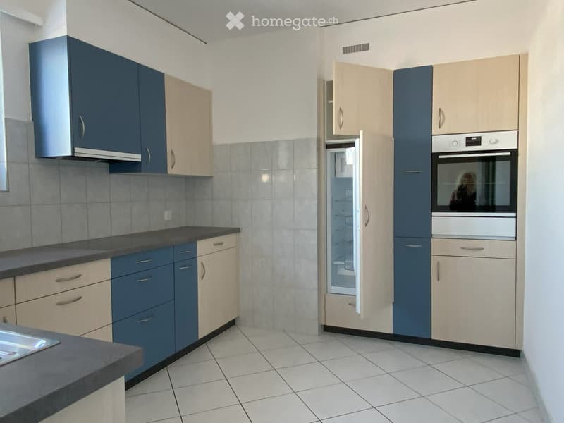modern kitchen, blue and beige cabinets, white tiled wall, stainless steel countertop, built-in appliances
