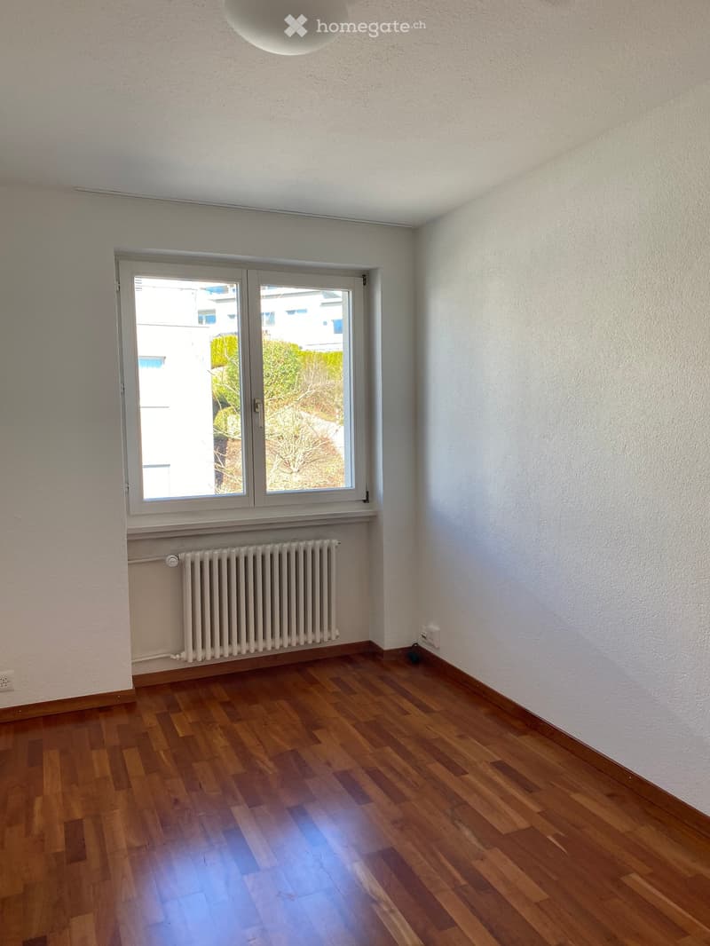 empty room, hardwood floors, large window, white radiator