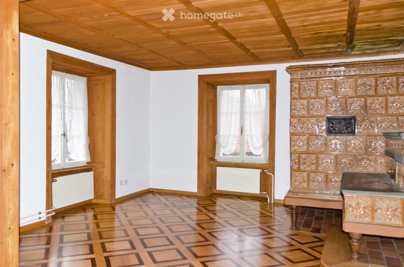 wooden ceiling, square patterned wooden floor, white walls, wooden window frames, white curtains, fireplace