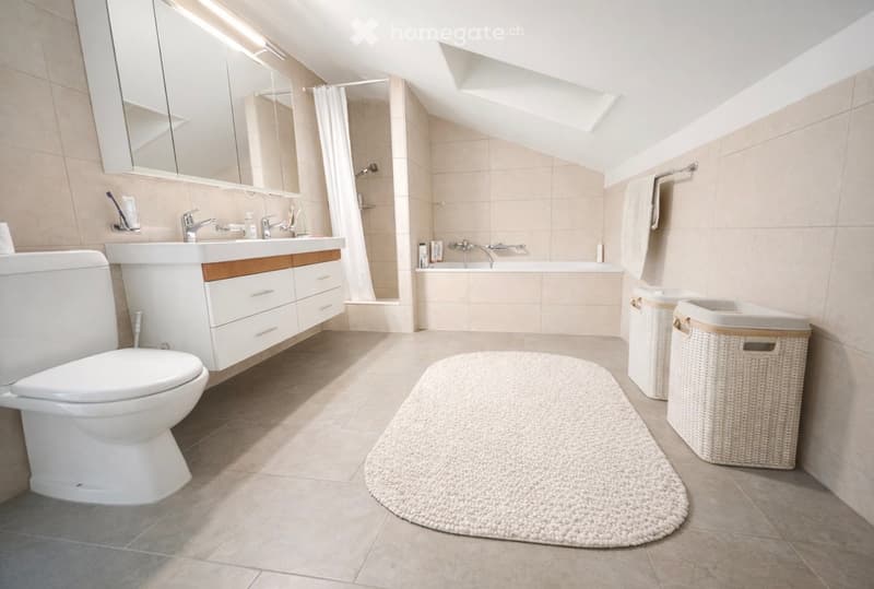 modern bathroom with a toilet, bathtub, sink, cabinets, and a shower