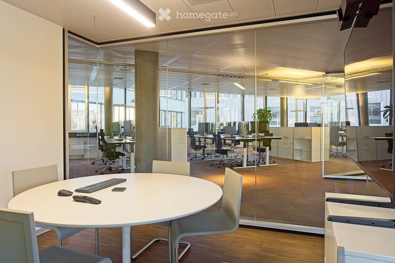 meeting room with round table, gray chairs, glass partition walls, large windows, interior with minimalist office design