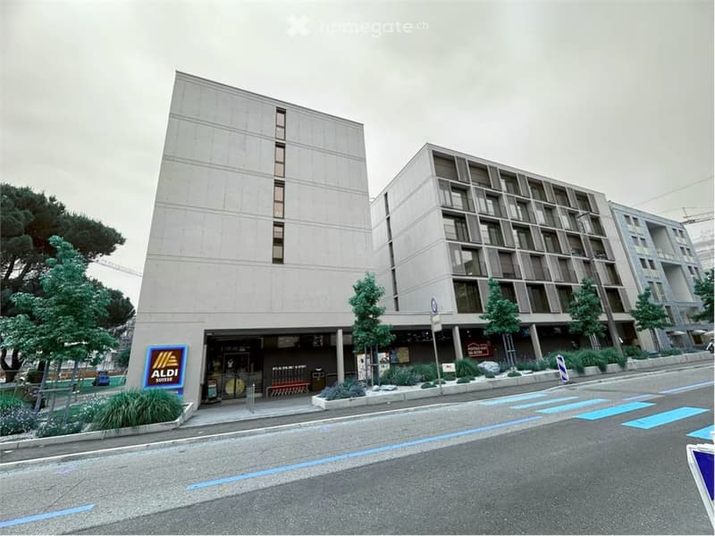 modern residential building, grey concrete, large windows, multiple stories, entry point, parking sign