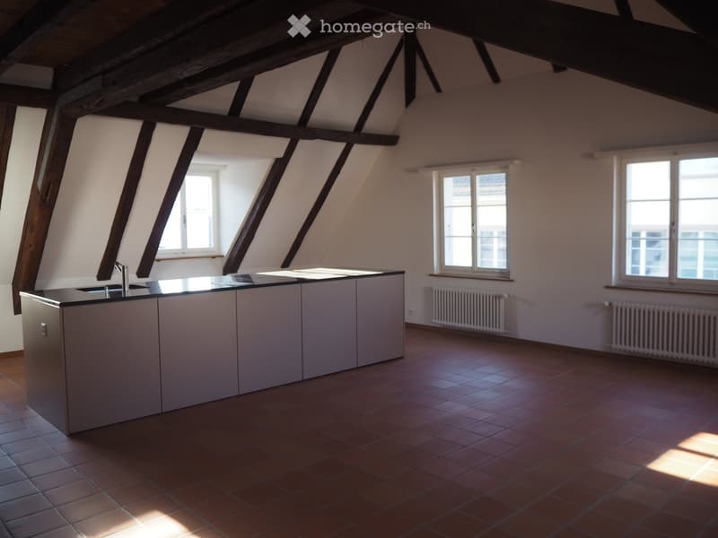 Kitchen: Kitchen counter, 2 white radiators, brown tile flooring, white walls, 3 windows