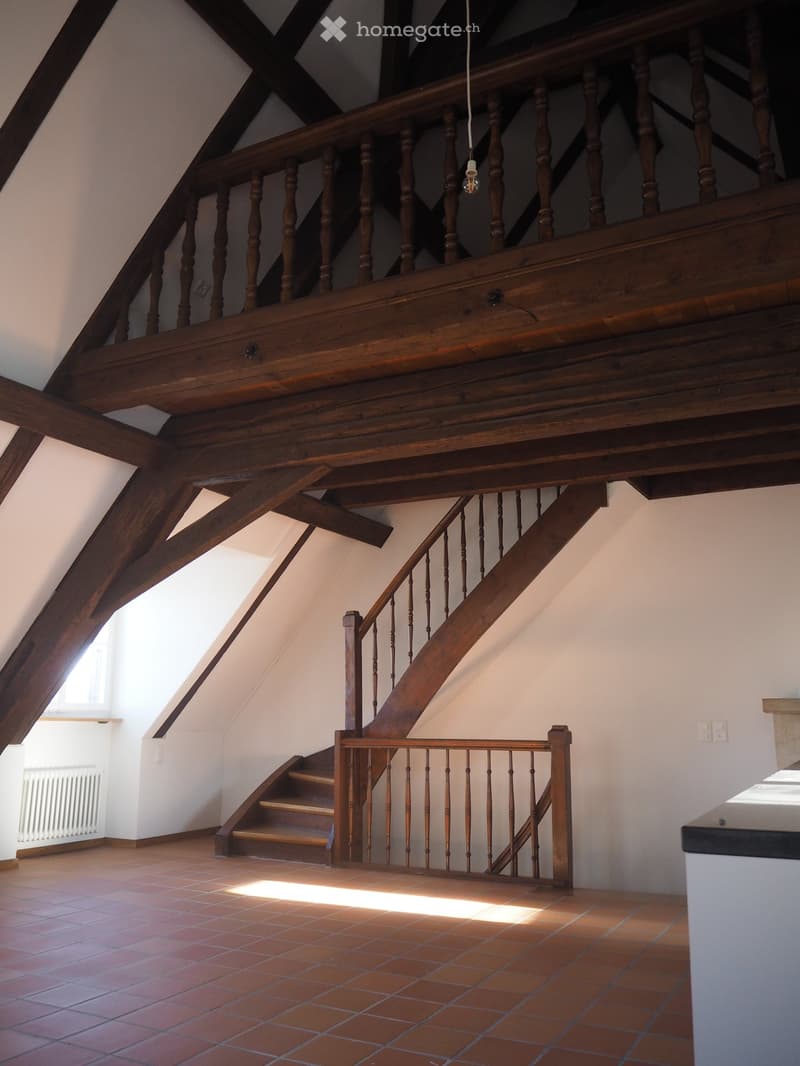 room with wooden beams, wooden stairs, brown tiles floor