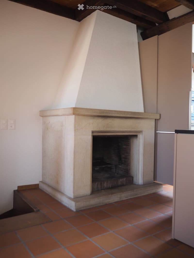 white painted walls, fireplace in center, tile floor, wooden ceiling