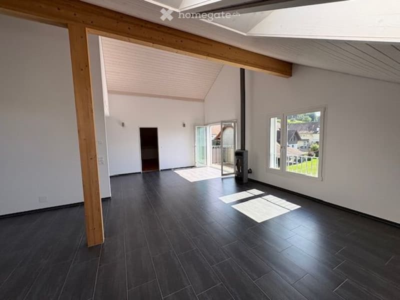 Empty room with wooden beam, fireplace, and sliding doors to a patio, tiled floor, large windows