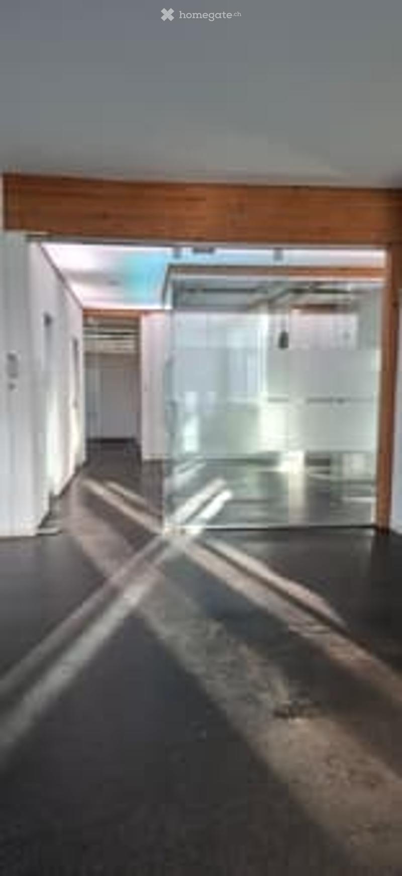 empty office space with glass wall, wooden beams, bright light