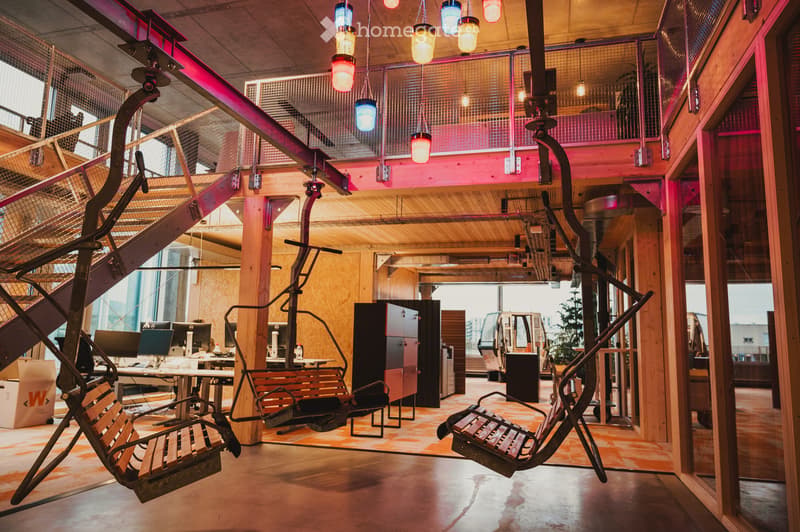 office with metal swing chairs, two large pillars, large window