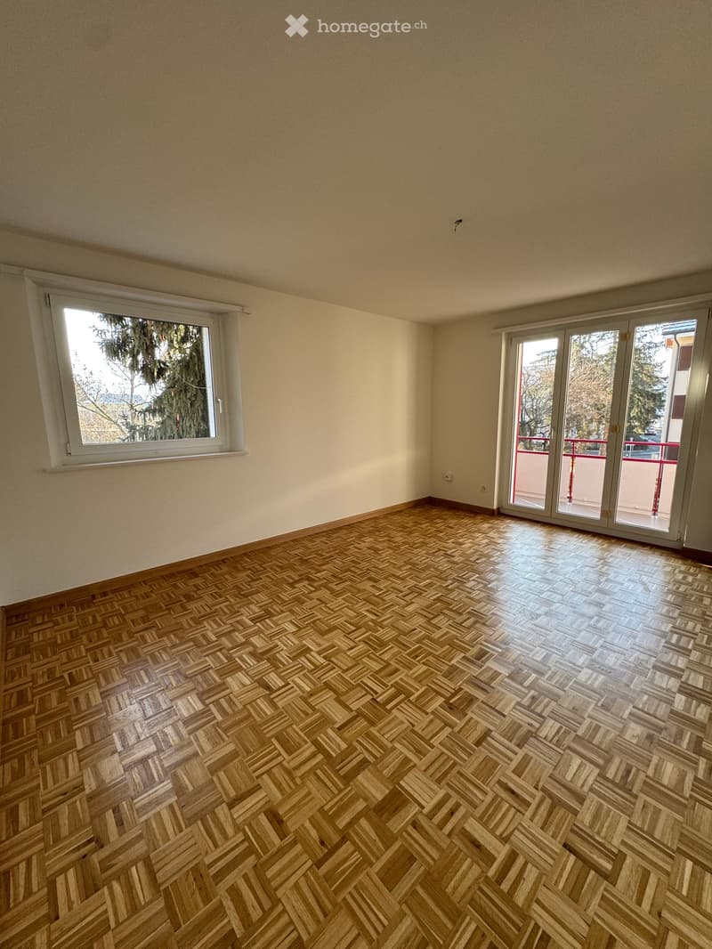 empty room, wooden parquet floor, sliding doors to balcony, window