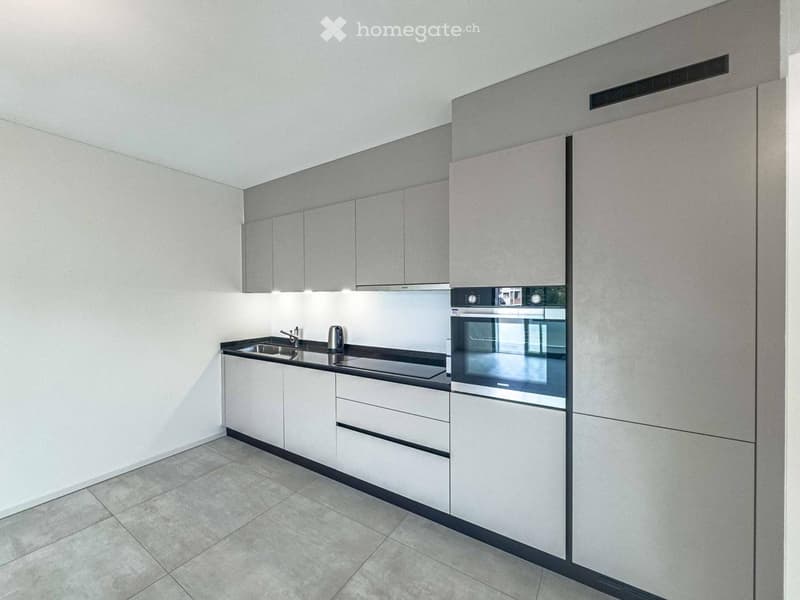 tiled floor, white cabinets, black countertop, stainless steel appliances, sink with faucet, modern design