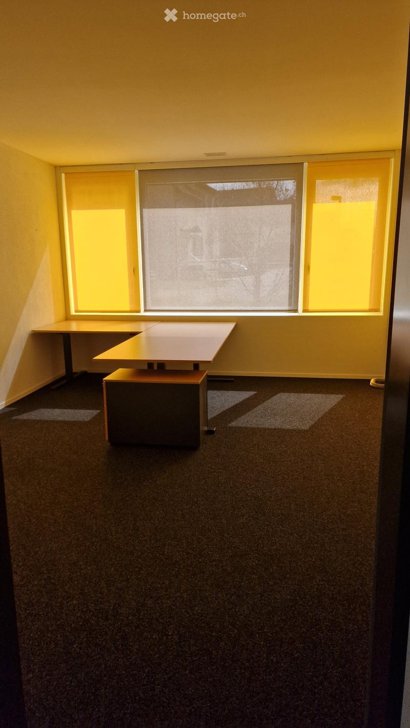 Empty room, two desks, windows, brown floor