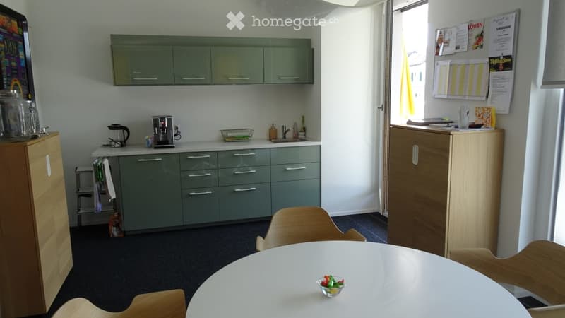 white table, green kitchen cupboards, wooden chairs, wooden cupboards
