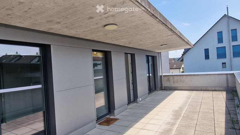 Modern balcony with tiled floor, large glass sliding doors, wooden ceiling, and built-in lighting.