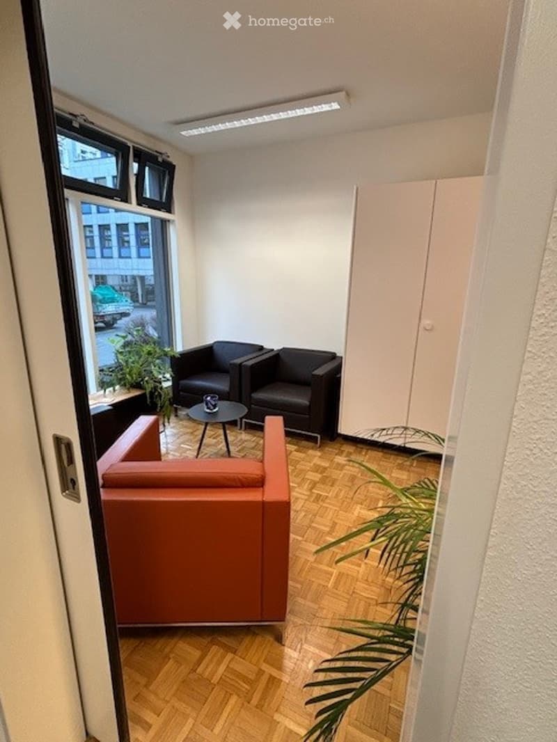 waiting area with 3 chairs, a round table, a closet, plants, windows