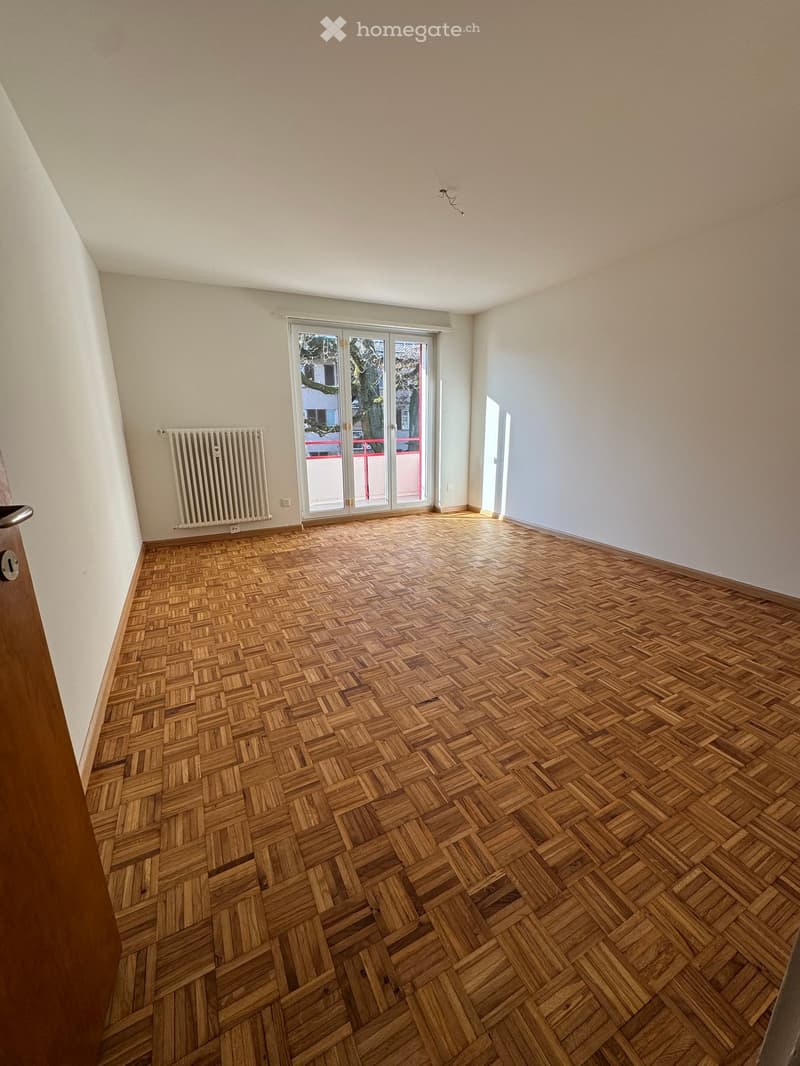 empty room, white walls, wooden floor, white radiator, glass door with balcony access