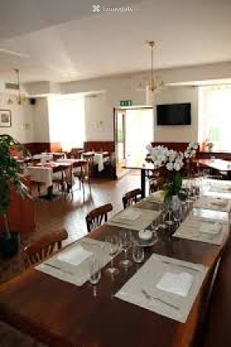 Dining tables with set up for dining, white cloths, glasses, cutlery, flowers in vase