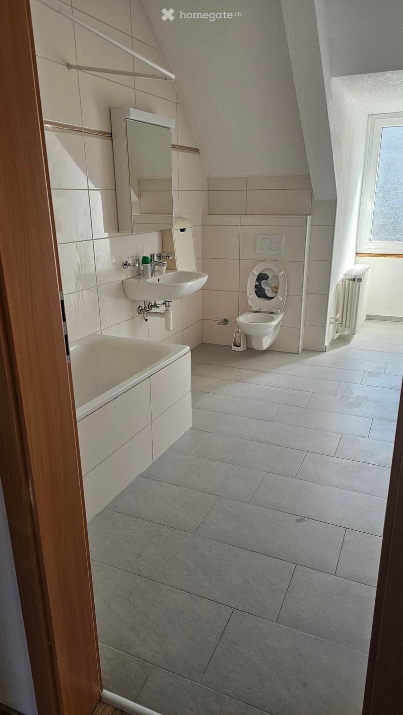 Bathroom with bathtub, sink, toilet, mirror, and heating