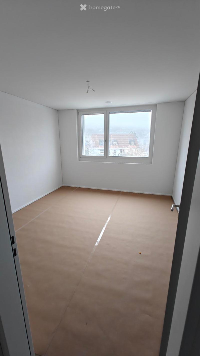 empty room, white walls, brown floor, large window, view of a house