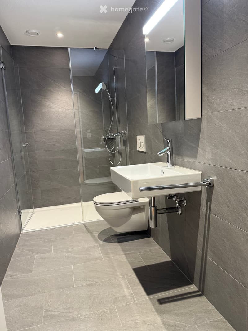 modern bathroom with shower, toilet, sink, showerhead, tiled floor, white walls