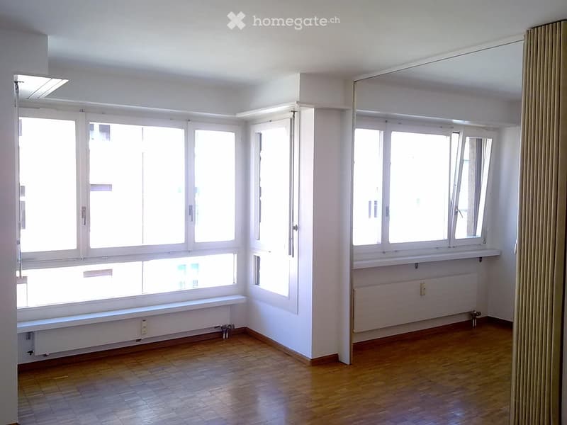 large windows, parquet floor, white walls, central heating radiators, no furniture