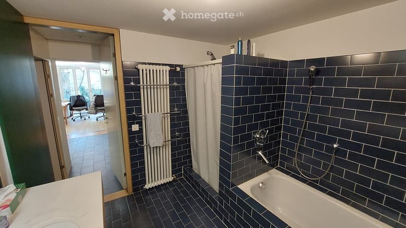 Bathroom: white bathtub, blue tiles, white shower curtain, towel rack, radiator, sink
