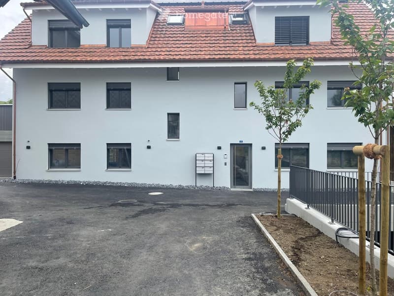 white house with red roof, 3 stories, 7 windows, solar panels, parking area