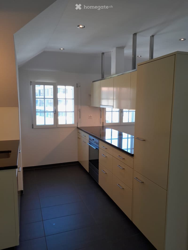 modern kitchen with white walls, black tiled floor, granite countertop, built-in oven and stove, large windows