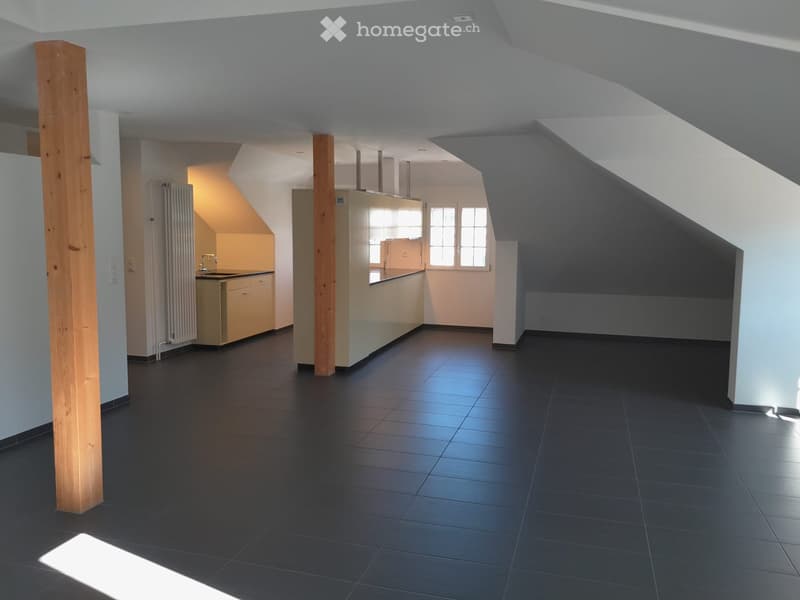 Empty room, tiled floor, kitchen area with sink, wooden beams, window