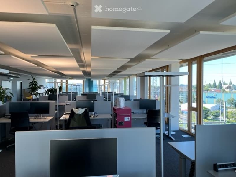 {"visible_features": [],    "type": "Office",    "description": "modern office with glass windows, several desks, chairs, plants, suspended ceiling, monitors, red filing cabinet",    "localized_descriptions":        {        "EN": "Modern office with
