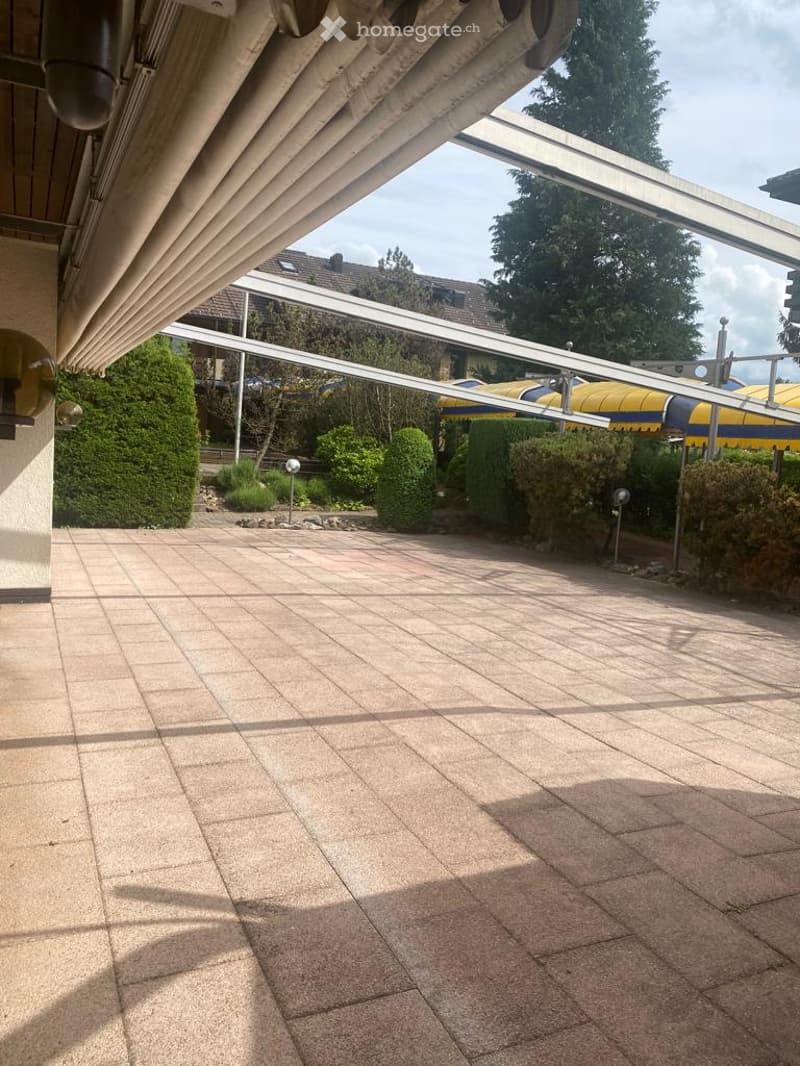 Brick flooring, shaded area, outdoor umbrellas, greenery